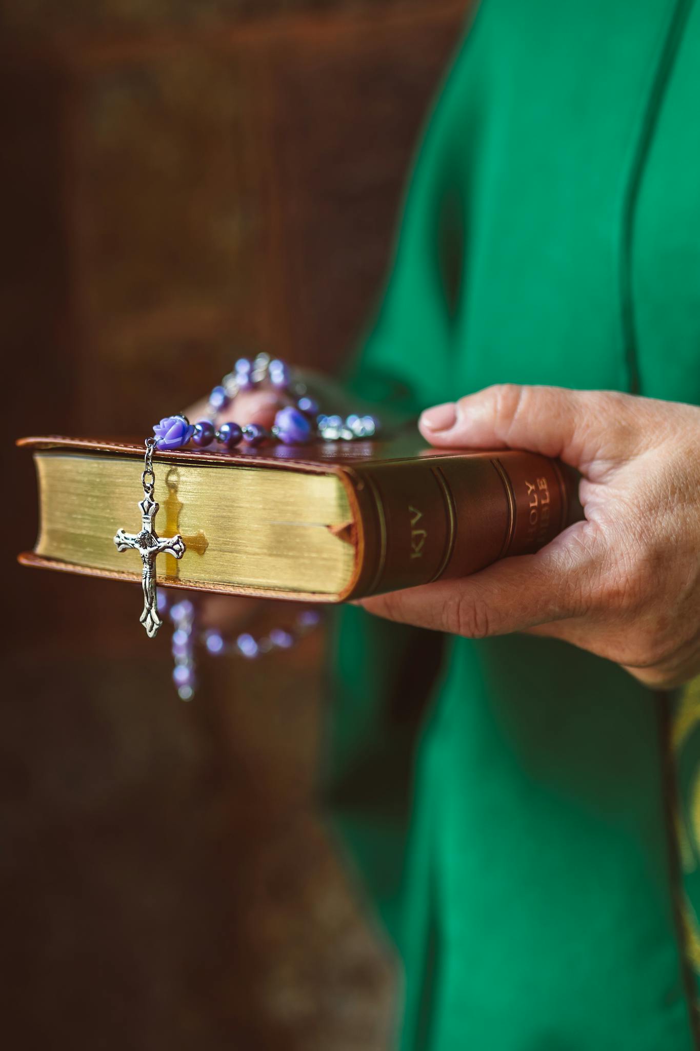 A person holding a Bible with a rosary, emphasizing faith and spirituality.